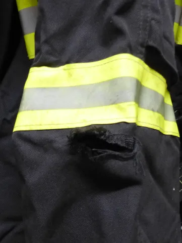 Risse im Oberstoff der Schutzkleidung